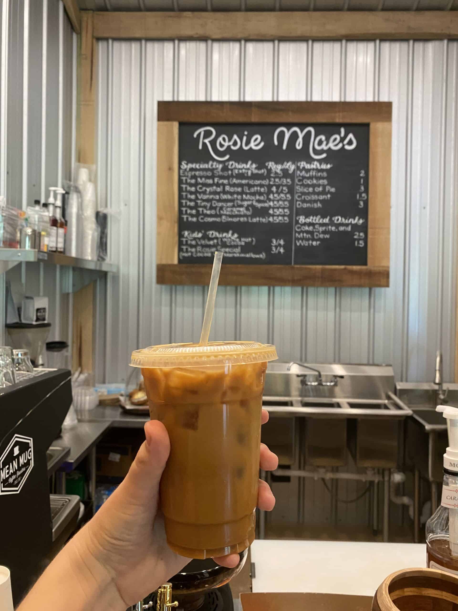 Holding a coffee inside Rosie Mae's 
