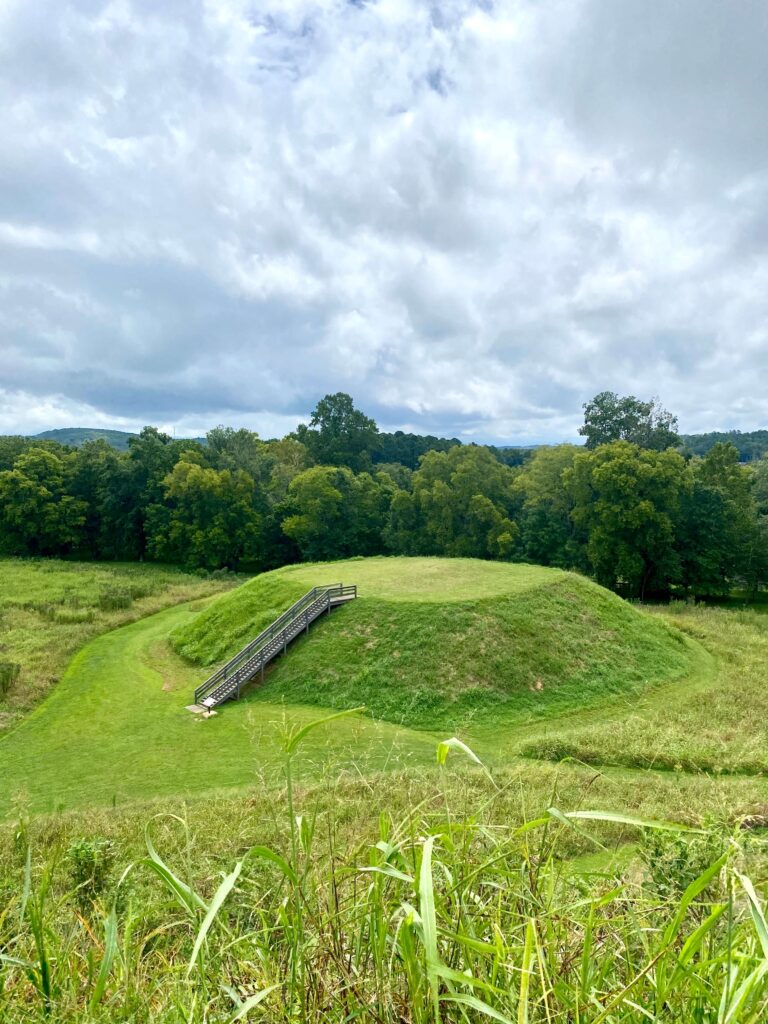 A green Indian mound with a staircase going to the top of it